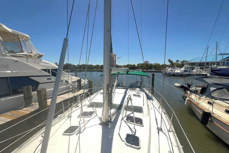 Slide: The Image of Sailing yacht Beneteau Oceanis 473, 2001 model, docked with green canopy, sunny marina. - 22