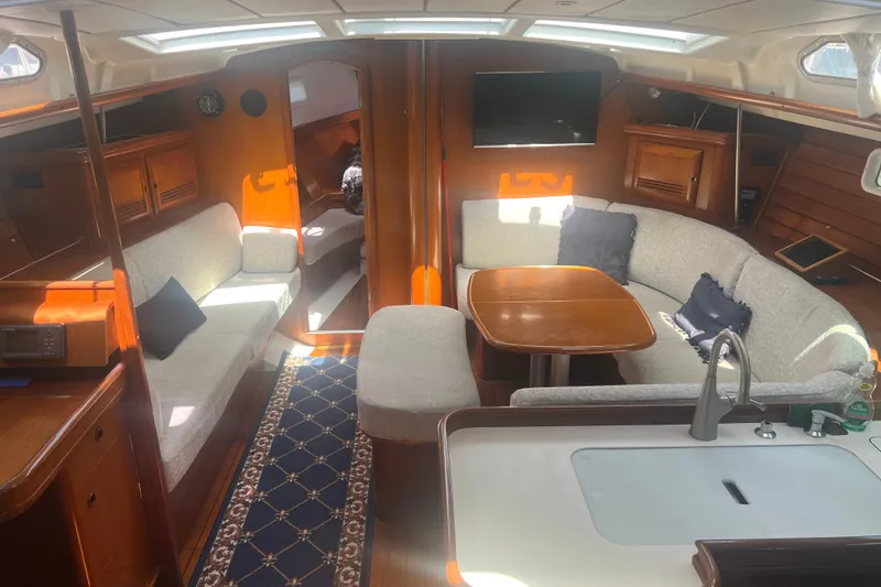 Slide: The Image of Interior of 2001 Beneteau Oceanis 473 yacht with wooden furnishings and cozy seating area. - 55