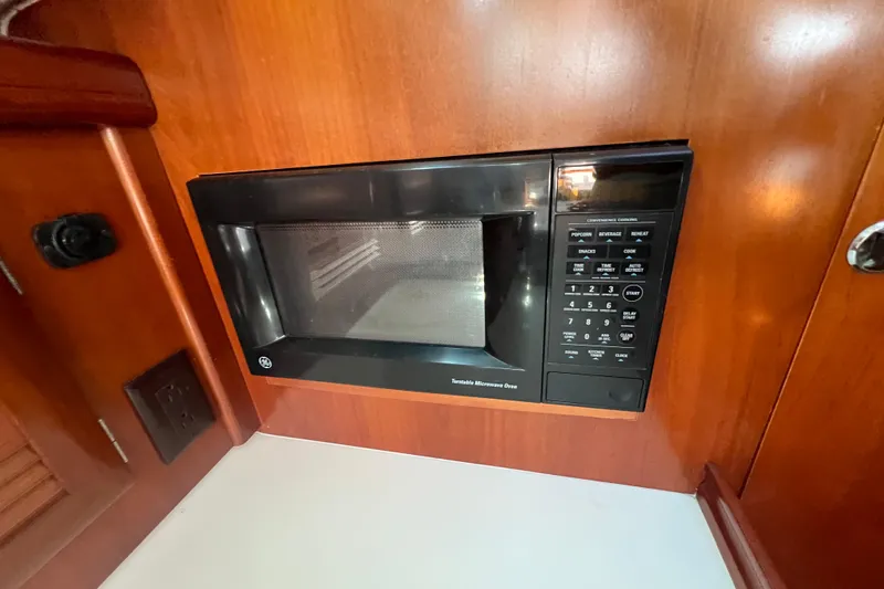 Slide: The Image of Interior of 2001 Beneteau Oceanis 473 yacht with wooden cabinetry and mounted TV. - 61