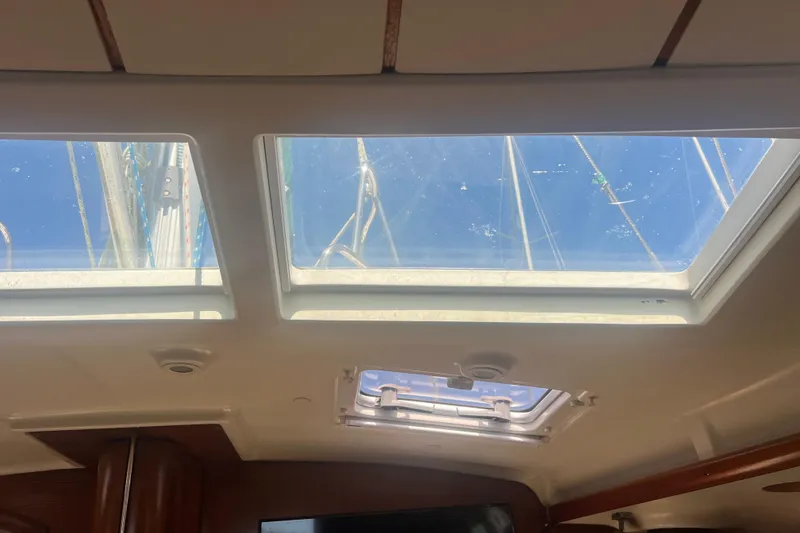 Slide: The Image of Interior view of 2001 Beneteau Oceanis 473 sailboat cabin with wooden finish and ceiling hatch. - 86