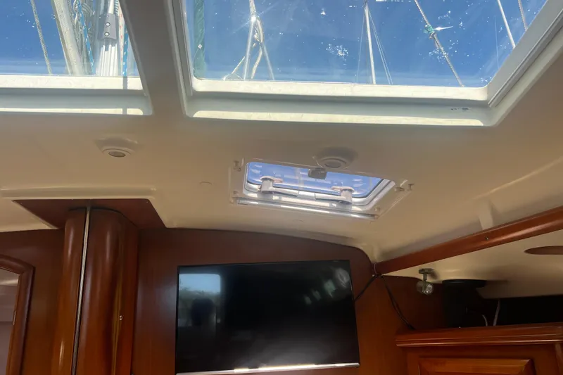 Slide: The Image of Cozy cabin interior of 2001 Beneteau 473 sailboat with wooden finish and plaid bedding. - 88