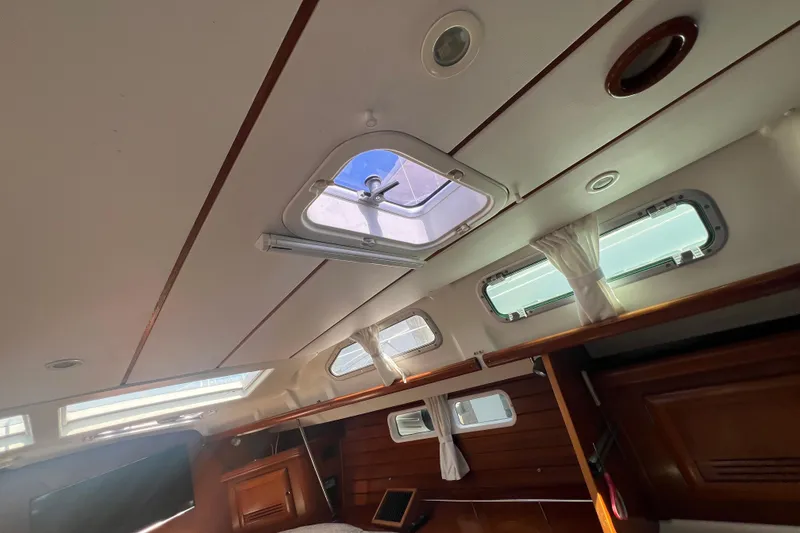 Slide: The Image of Cozy cabin interior of 2001 Beneteau 473 yacht with wood paneling and plaid bedding. - 91