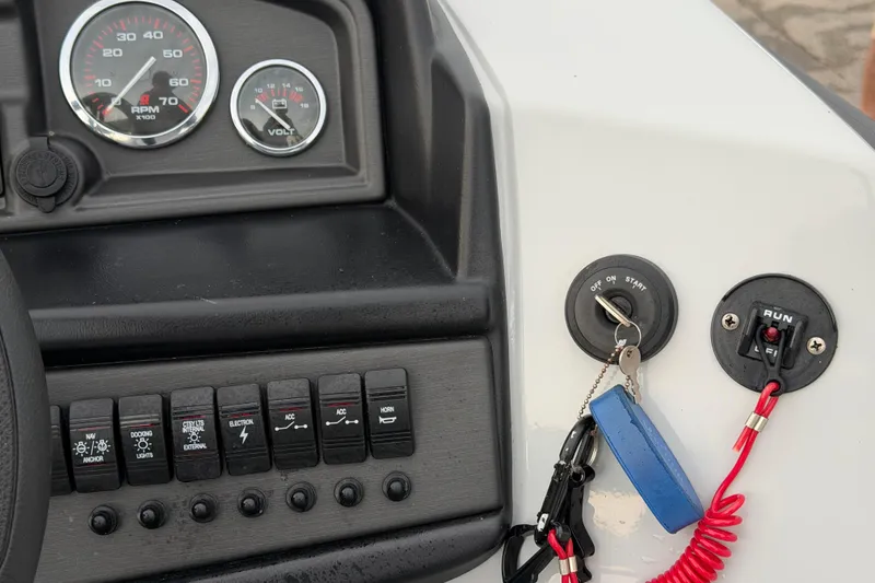 Slide: The Image of Dashboard of 2023 Bentley Pontoons Legacy 200 Cruise with gauges and ignition key. - 10