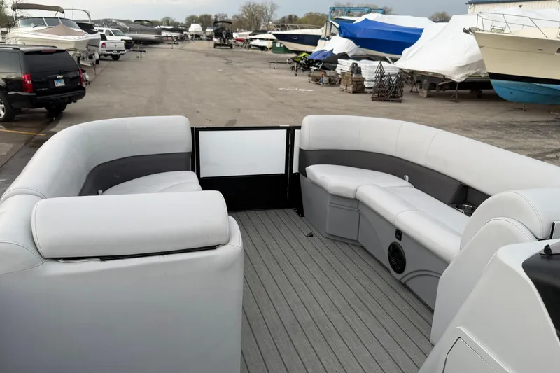 Slide: The Image of 2023 Bentley Pontoons Legacy 200 Cruise interior with spacious seating in a marina setting. - 17