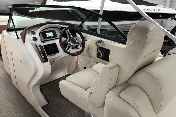 Slide: The Image of Interior of 2017 Larson Escape 213 boat with modern steering and beige seating. - 11