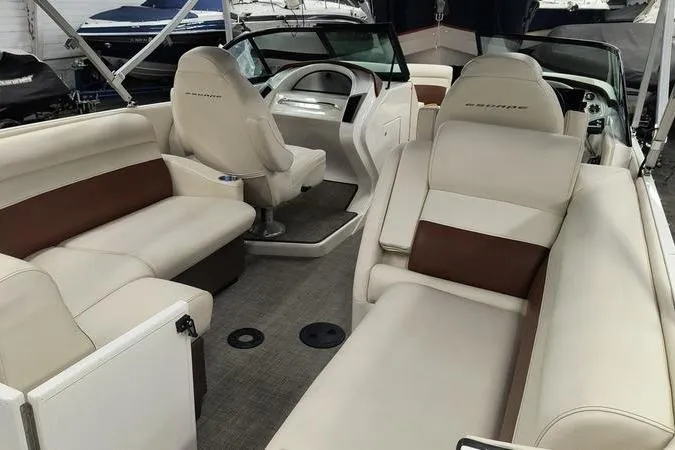 Slide: The Image of Interior of a 2017 Larson Escape 213 boat with beige seating and modern dashboard. - 13