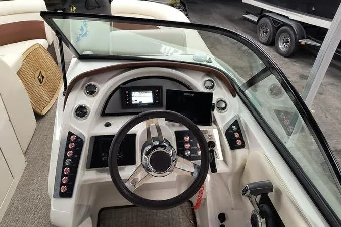 Slide: The Image of Cockpit view of a 2017 Larson Escape 213 boat with steering wheel and dashboard controls. - 15