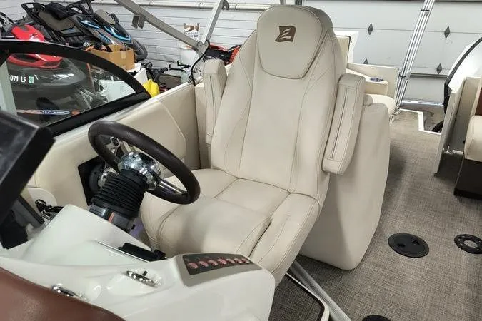 Slide: The Image of Captain's seat in 2017 Larson Escape 213 boat, featuring a sleek steering wheel and modern controls. - 18