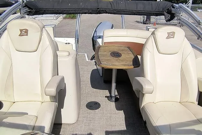 Slide: The Image of 2017 Larson Escape 213 boat interior with beige seating and wooden table. - 19