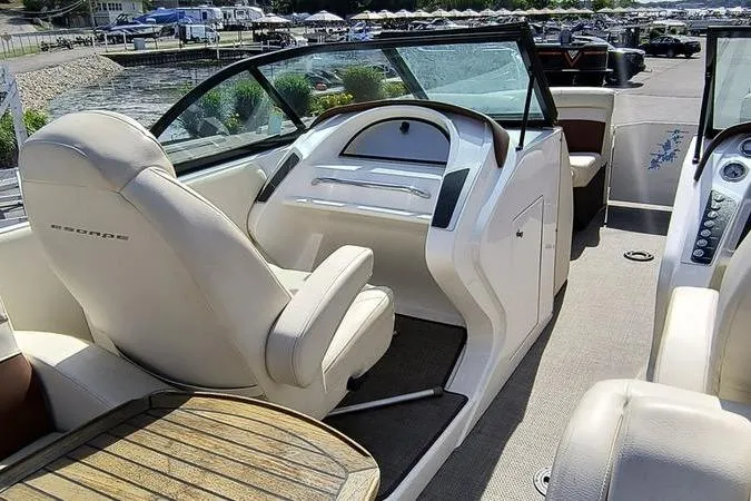 Slide: The Image of 2017 Larson Escape 213 boat interior with helm, seating, and wooden table. - 4