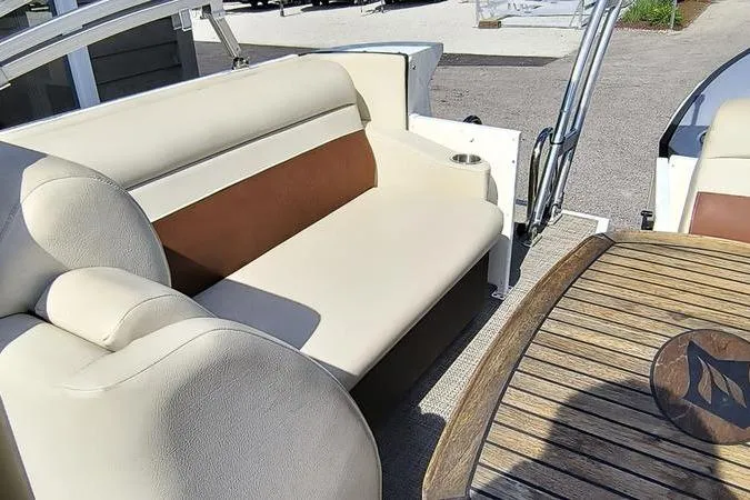 Slide: The Image of Interior of 2017 Larson Escape 213 boat with beige seating and wooden table. - 6