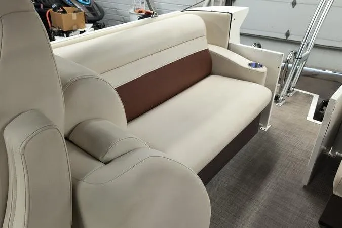 Slide: The Image of 2017 Larson Escape 213 boat interior with beige and brown seating, cup holder, and carpeted floor. - 8