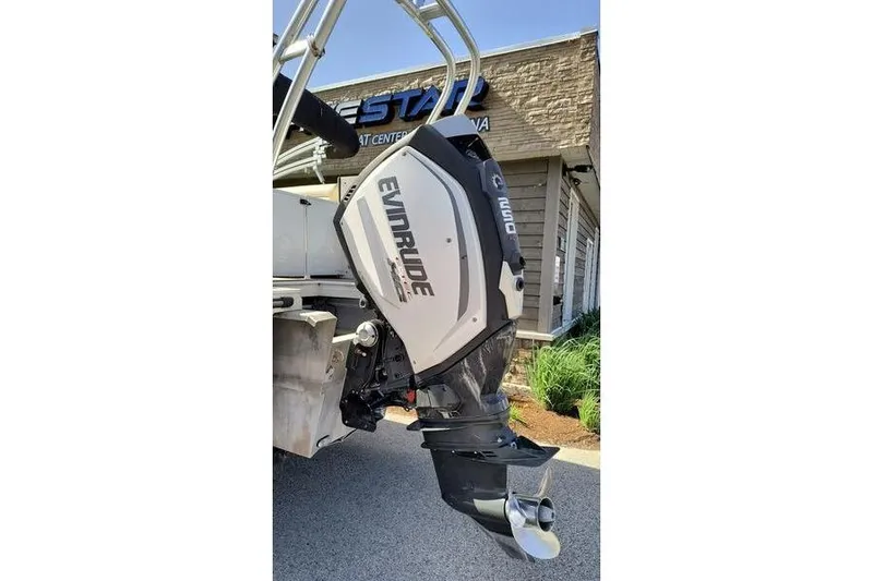 Slide: The Image of 2017 Larson Escape 213 with Evinrude outboard motor at a marina. - 9