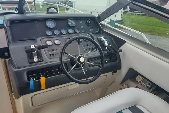 Slide: The Image of 1991 Sea Ray 280 Weekender boat dashboard with steering wheel and control panel. - 12
