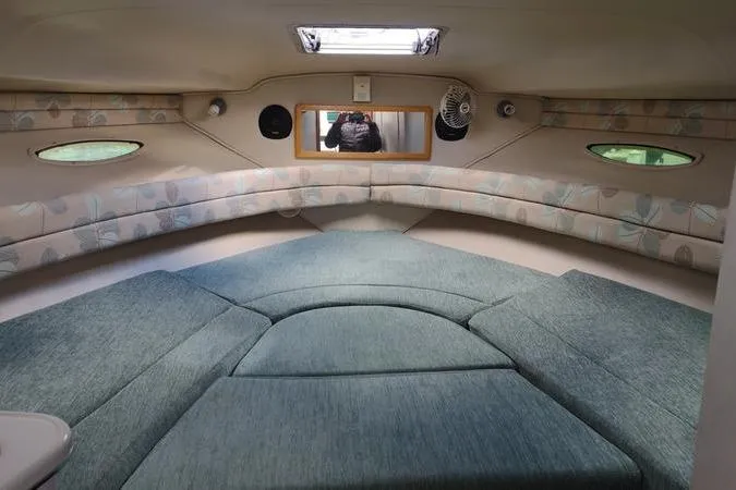 Slide: The Image of Interior cabin of 1991 Sea Ray 280 Weekender with teal upholstery and porthole windows. - 22