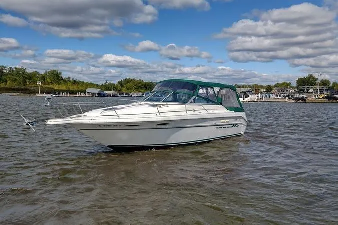 Slide: The Image of 1991 Sea Ray 280 Weekender boat on calm water under a partly cloudy sky. - 3
