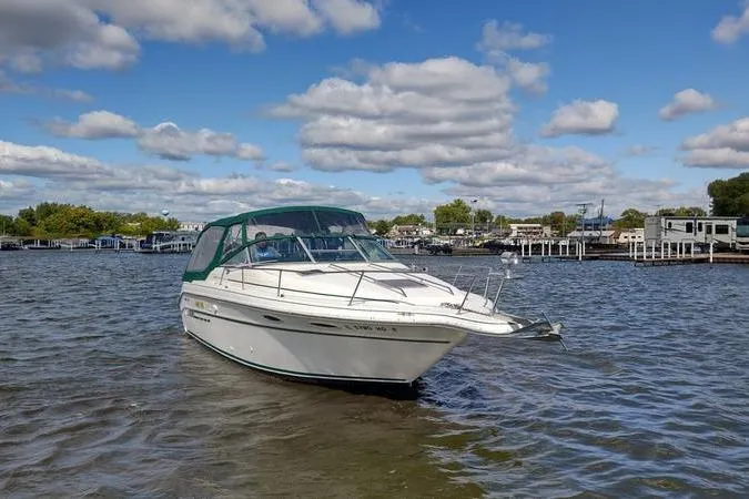 Slide: The Image of 1991 Sea Ray 280 Weekender boat on a calm lake under a partly cloudy sky. - 4