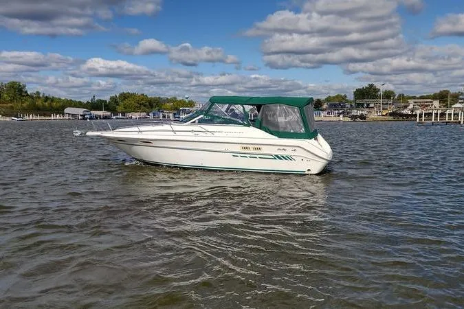 Slide: The Image of 1991 Sea Ray 280 Weekender boat on a calm lake under a partly cloudy sky. - 5