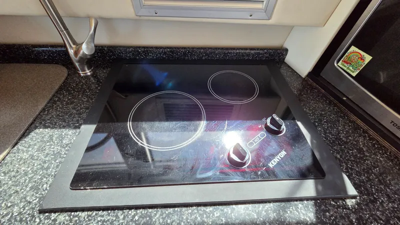 Slide: The Image of Carver 450 Voyager Pilothouse kitchen with Kenyon cooktop. - 20