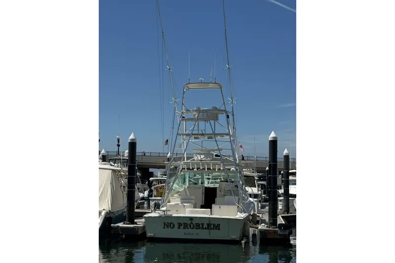 Slide: The Image of 1998 Cabo Yachts 35 Express docked at marina, clear sky background. - 10