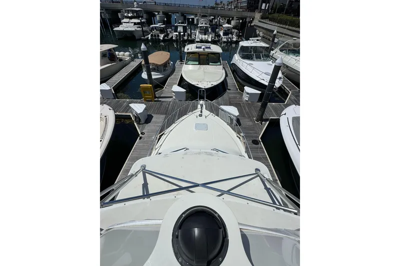 Slide: The Image of 1998 Cabo Yachts 35 Express docked among other boats in a marina. - 11