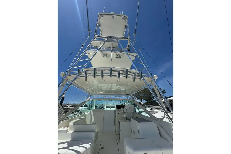 Slide: The Image of 1998 Cabo Yachts 35 Express with tower, sleek design under clear blue sky. - 12