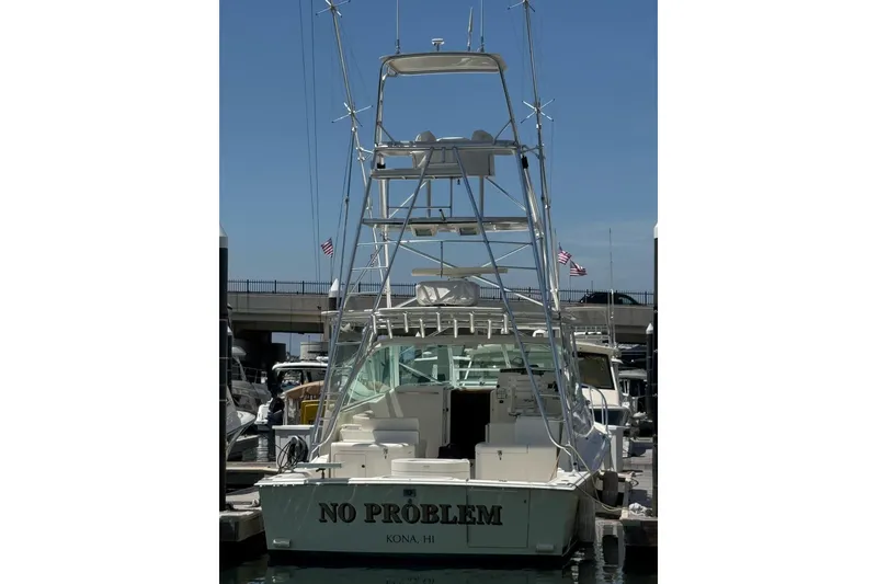 Slide: The Image of 1998 Cabo Yachts 35 Express docked, rear view with tower and "No Problem" name. - 15