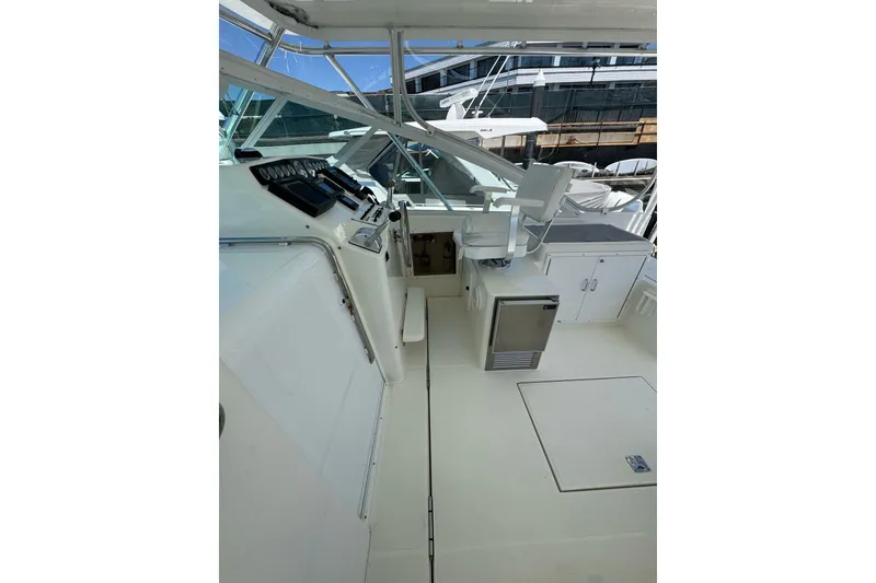 Slide: The Image of 1998 Cabo Yachts 35 Express cockpit with helm, seating, and storage cabinets. - 19