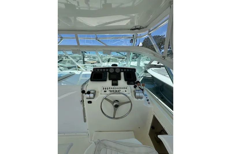 Slide: The Image of Helm of 1998 Cabo Yachts 35 Express with steering wheel and navigation controls. - 21