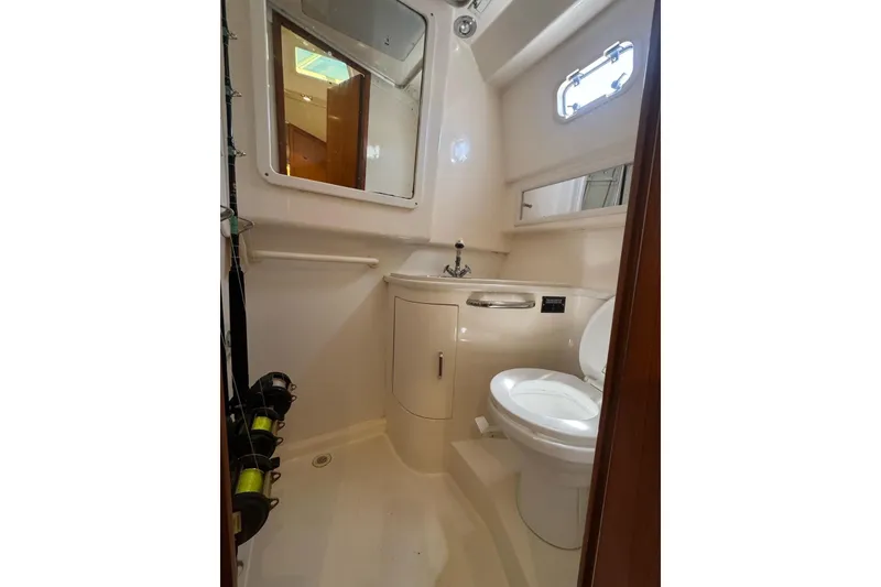Slide: The Image of Bathroom interior of 1998 Cabo Yachts 35 Express, featuring toilet, sink, and mirror. - 24