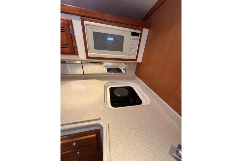 Slide: The Image of 1998 Cabo Yachts 35 Express kitchen with microwave and stovetop. - 25