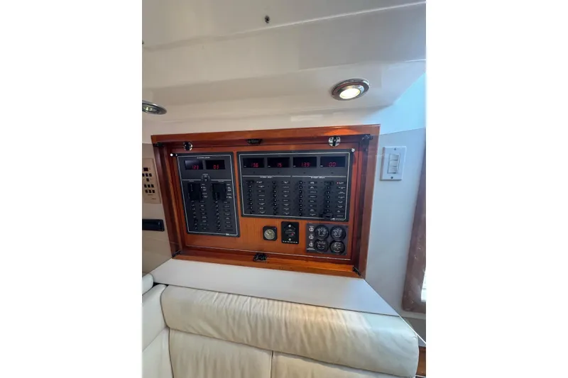 Slide: The Image of Electrical panel inside 1998 Cabo Yachts 35 Express, featuring switches and gauges. - 26