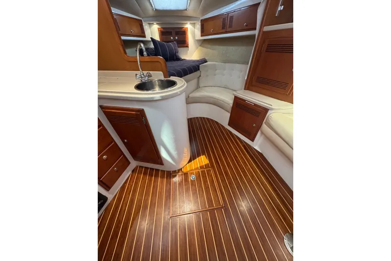 Slide: The Image of Interior of 1998 Cabo Yachts 35 Express with wood flooring and compact kitchenette. - 31