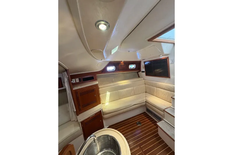 Slide: The Image of Interior of 1998 Cabo Yachts 35 Express with wood flooring and cream seating. - 33