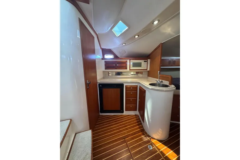 Slide: The Image of Interior of 1998 Cabo Yachts 35 Express, featuring kitchenette with wood accents and modern amenities. - 34