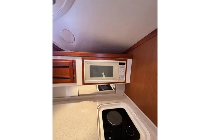 Slide: The Image of 1998 Cabo Yachts 35 Express kitchen with microwave and stovetop. - 38