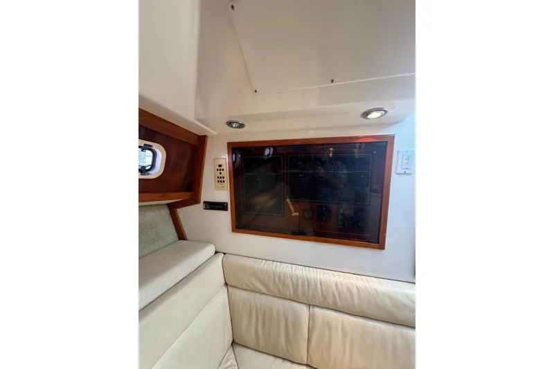 Slide: The Image of Interior of 1998 Cabo Yachts 35 Express, featuring control panel and cushioned seating. - 39