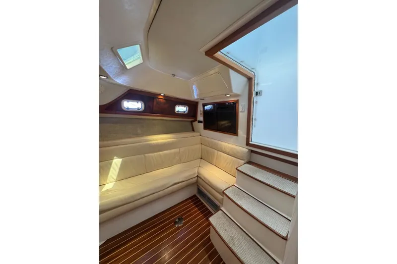 Slide: The Image of Interior of 1998 Cabo Yachts 35 Express, featuring cozy seating and wooden flooring. - 40