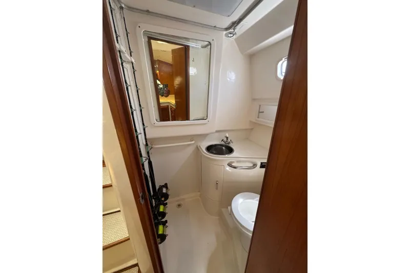 Slide: The Image of 1998 Cabo Yachts 35 Express bathroom with sink, toilet, and mirror. - 41