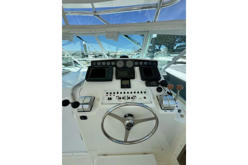 Slide: The Image of Helm of 1998 Cabo Yachts 35 Express with steering wheel and navigation controls. - 47