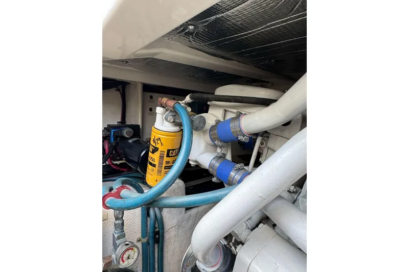 Slide: The Image of Engine compartment of a 1998 Cabo Yachts 35 Express, featuring hoses and a CAT filter. - 49