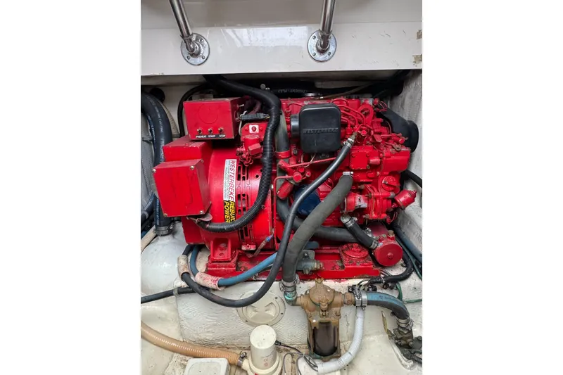 Slide: The Image of Engine compartment of a 1998 Cabo Yachts 35 Express, featuring a red Westerbeke generator. - 50