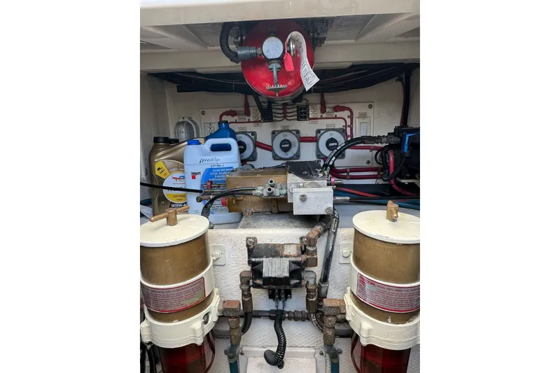 Slide: The Image of Engine compartment of a 1998 Cabo Yachts 35 Express with fuel filters and oil containers. - 56
