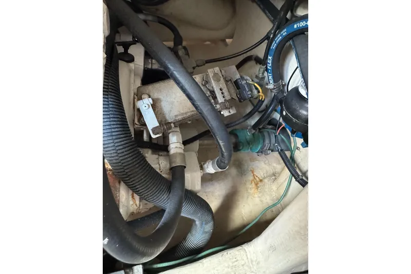 Slide: The Image of Engine compartment of a 1998 Cabo Yachts 35 Express, showcasing hoses and mechanical components. - 64