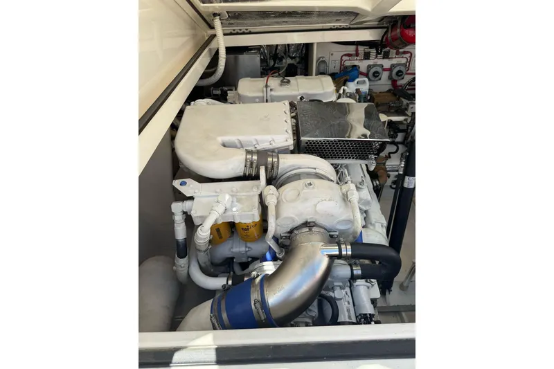 Slide: The Image of Engine compartment of a 1998 Cabo Yachts 35 Express, showcasing mechanical components and piping. - 65