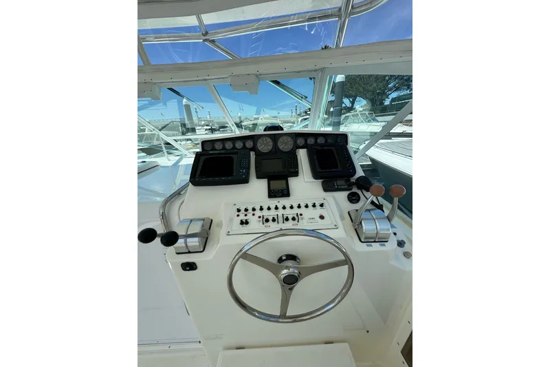 Slide: The Image of Helm of 1998 Cabo Yachts 35 Express with navigation instruments and steering wheel. - 68