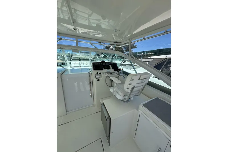 Slide: The Image of 1998 Cabo Yachts 35 Express helm with white seating and control panel. - 69