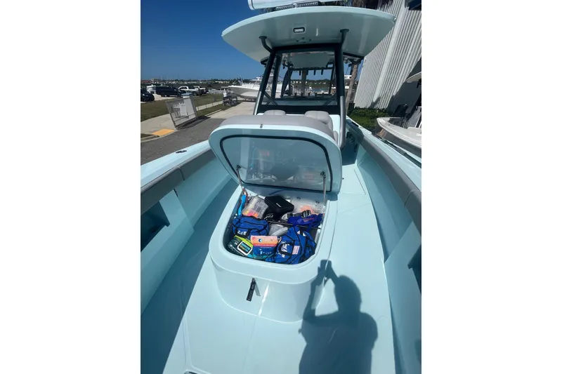 Slide: The Image of 2024 Front Runner boat with open storage compartment, docked under clear blue sky. - 11