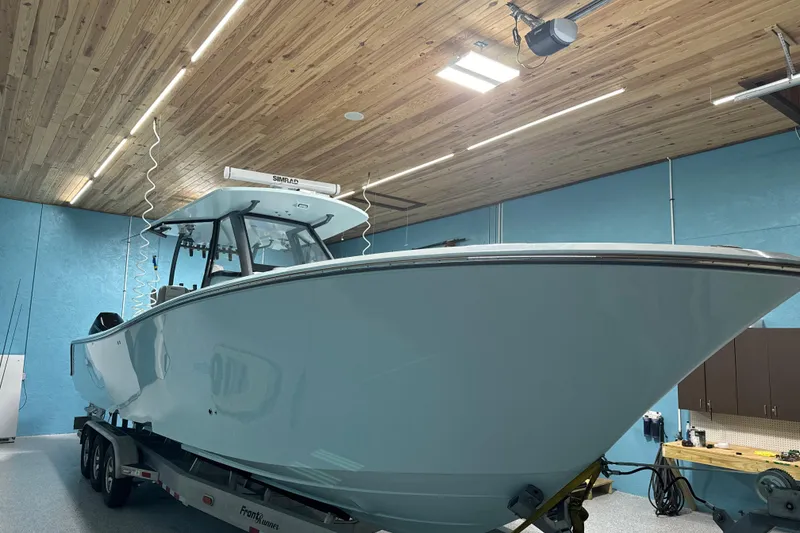 Slide: The Image of 2024 Front Runner boat in a wooden-ceiling garage, mounted on a trailer. - 3