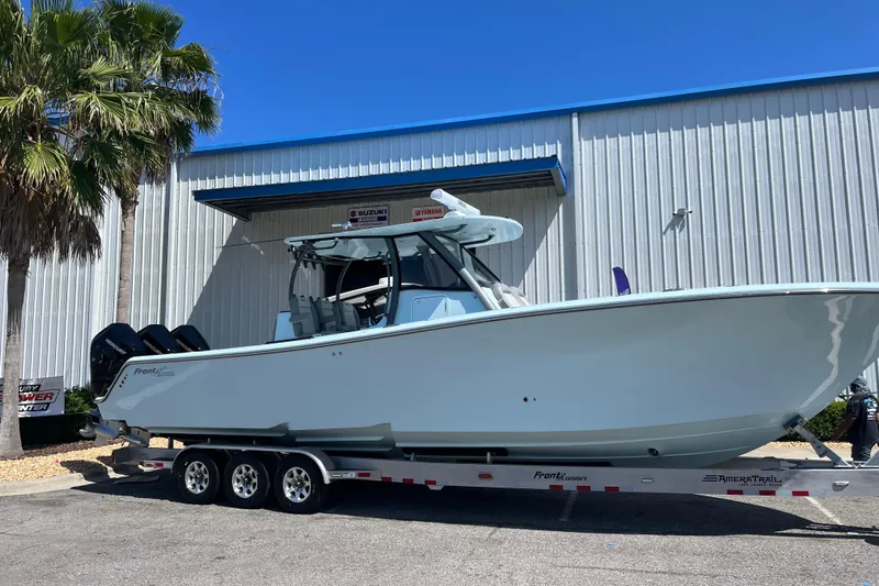 Slide: The Image of 2024 Front Runner boat on trailer, parked outside a metal building under clear blue sky. - 4